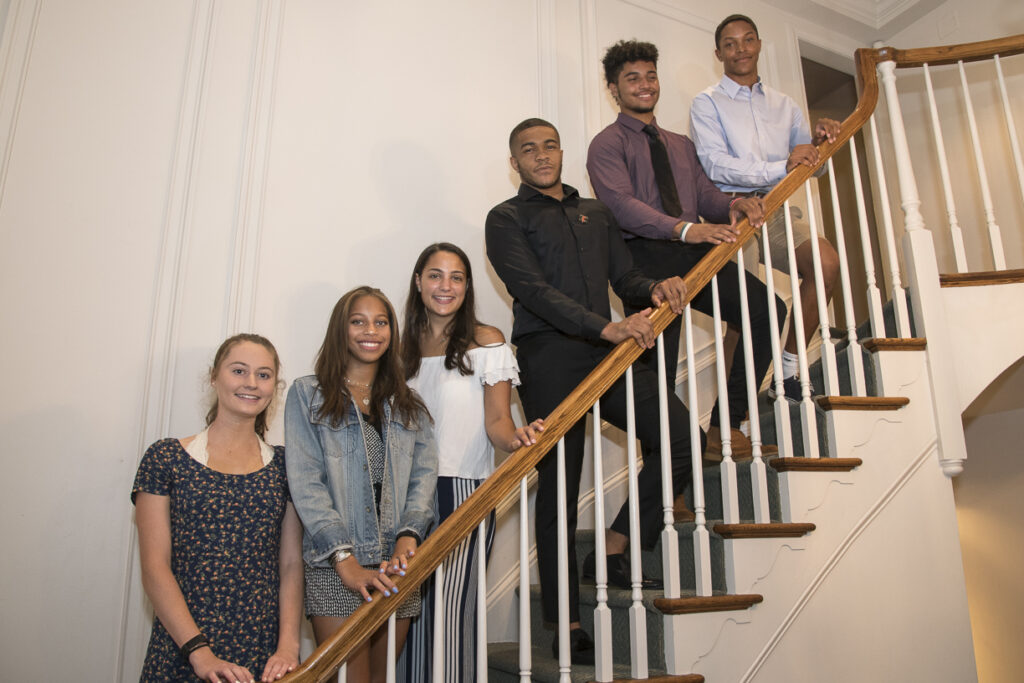 A group of people standing in the stairs while smiling